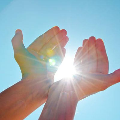 Hands holding the sun with the blue sky background. Hands holding the sun with the blue sky background.